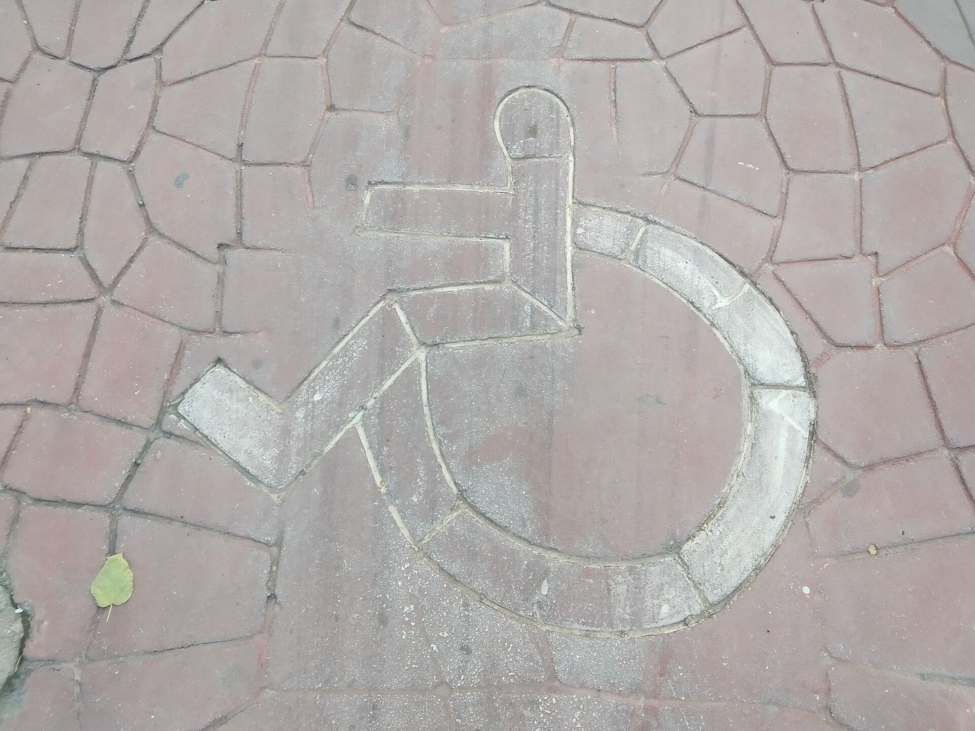 International wheelchair accessibility symbol painted onto a paved surface