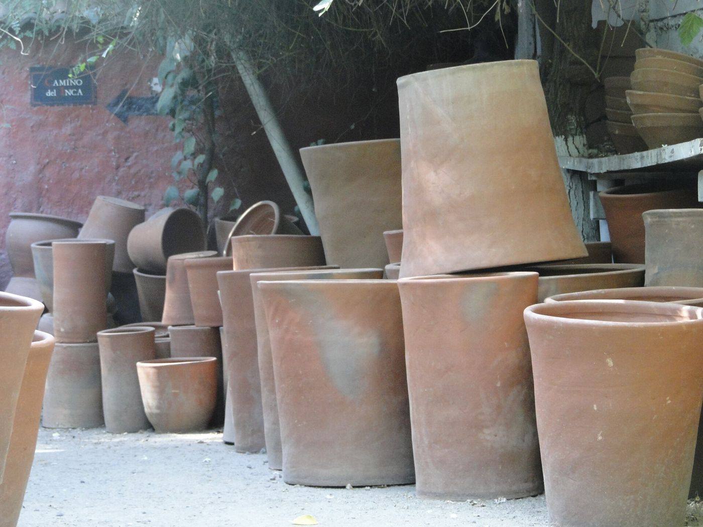 Stacks of unglazed terracotta pots and ceramics outside a workshop at Pueblito Los Dominicos, Santiago