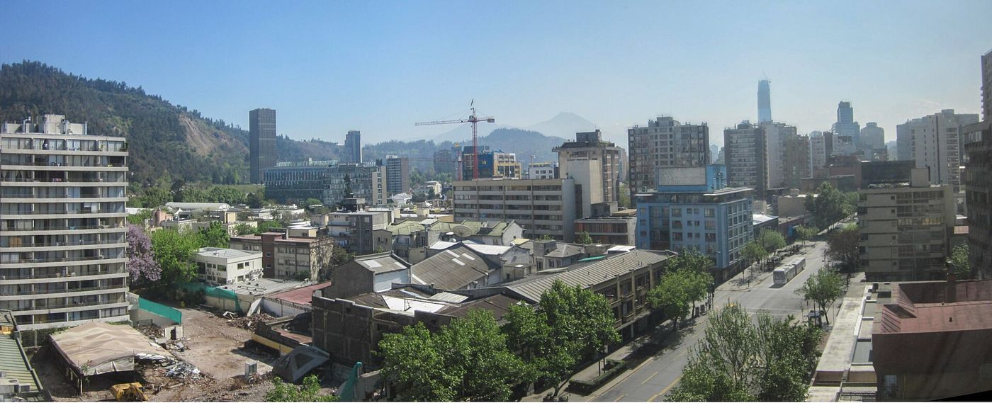 Traffic and office buildings along Avenida Providencia in Santiago on a clear day
