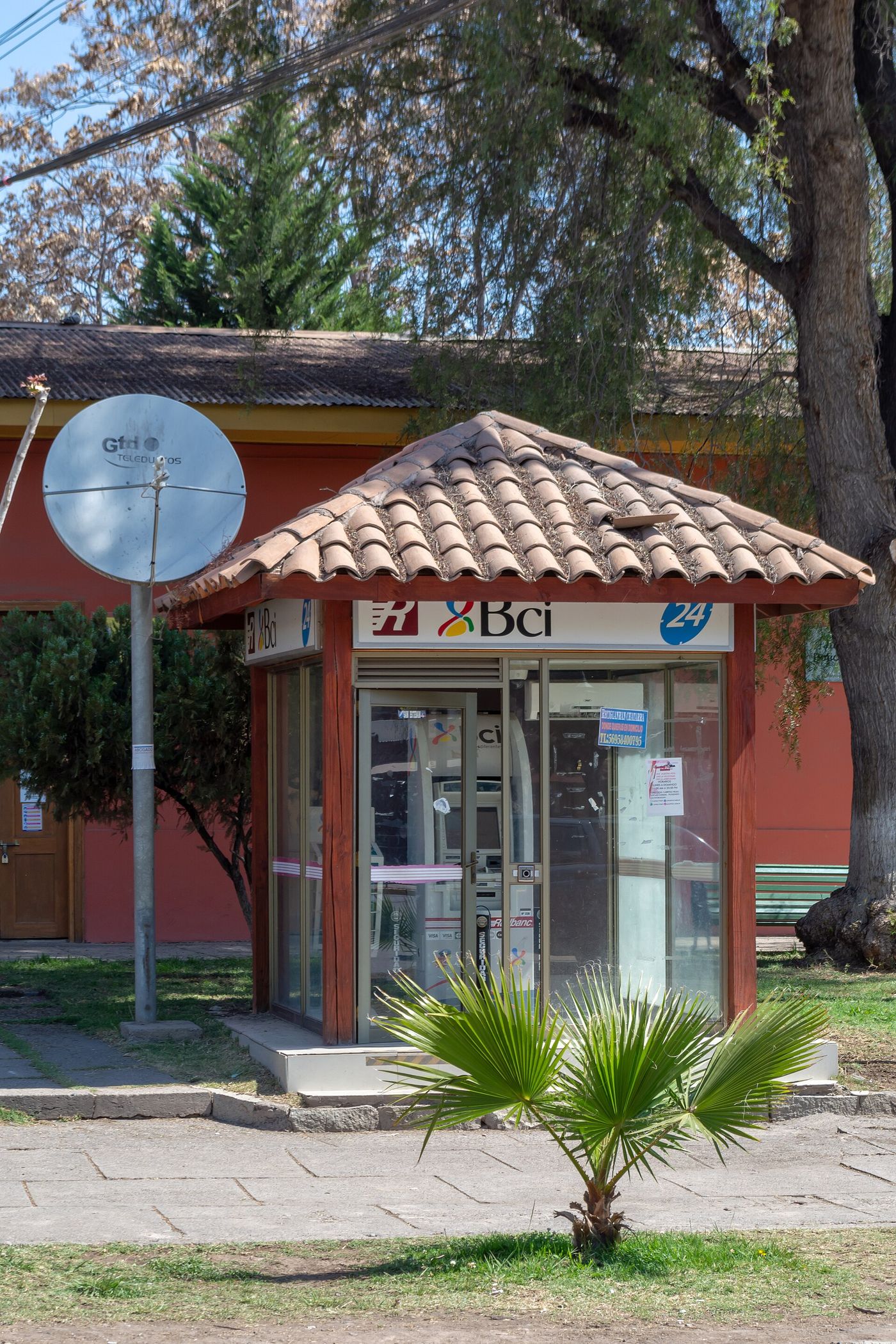 Free-standing BCI cash machine kiosk beside a street in Chile, surrounded by trees
