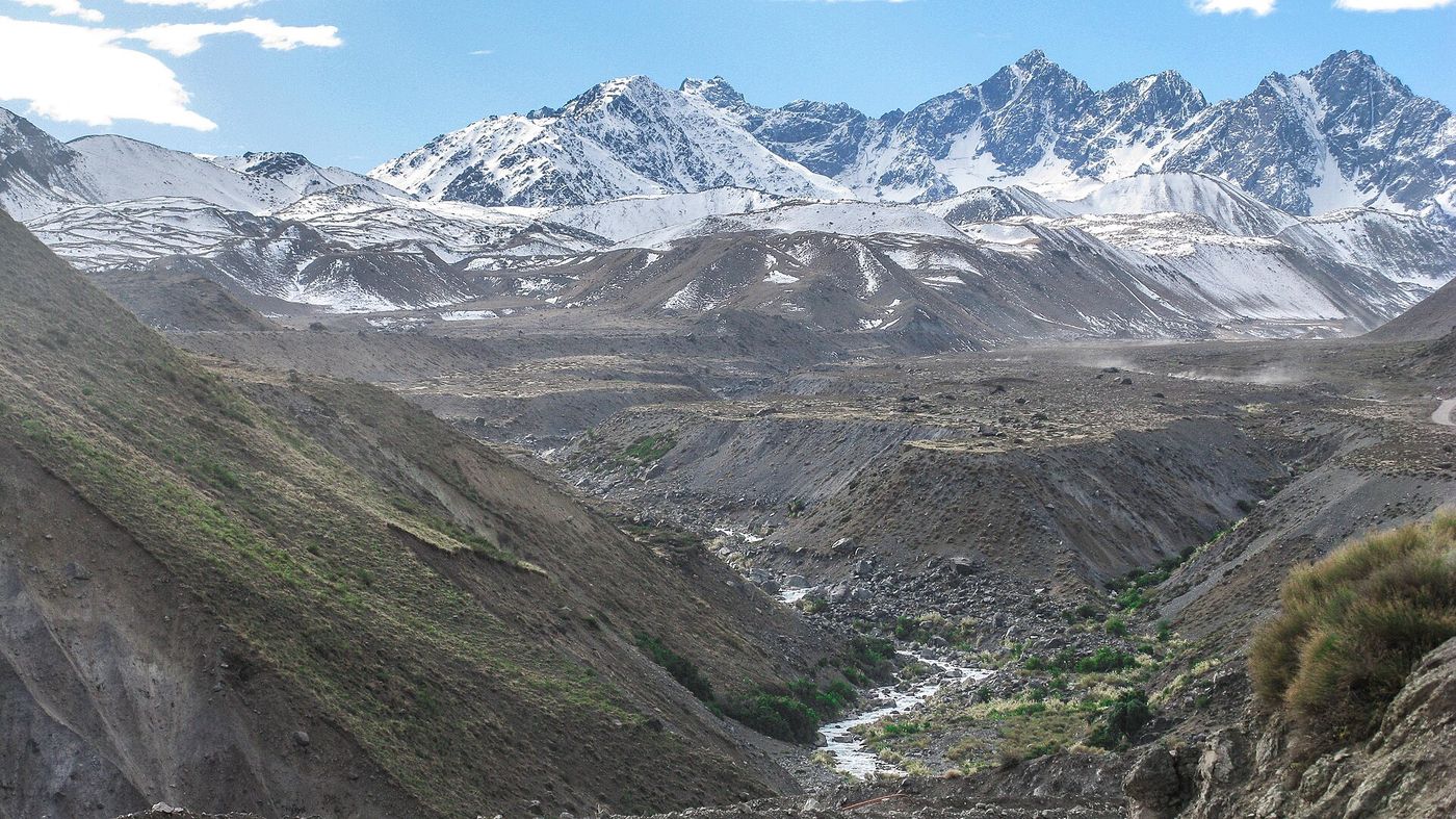 River running through a broad valley in the Cajon del Maipo with snow-covered Andean peaks at the head of the valley
