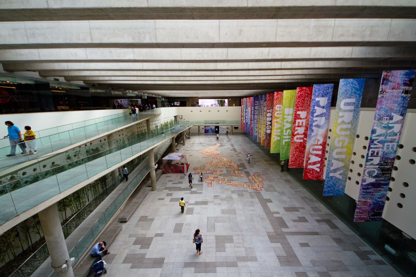 Wide underground concourse of the Centro Cultural La Moneda in Santiago, with exhibition banners along one wall