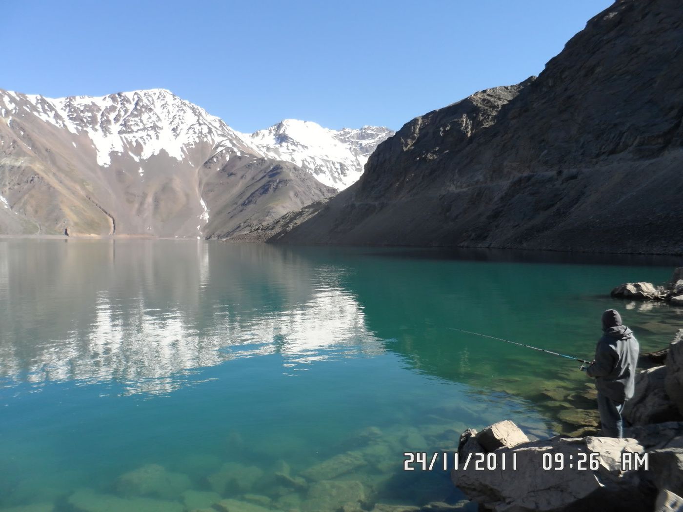 Turquoise water of the Embalse El Yeso below snow-streaked Andean peaks in the Cajon del Maipo