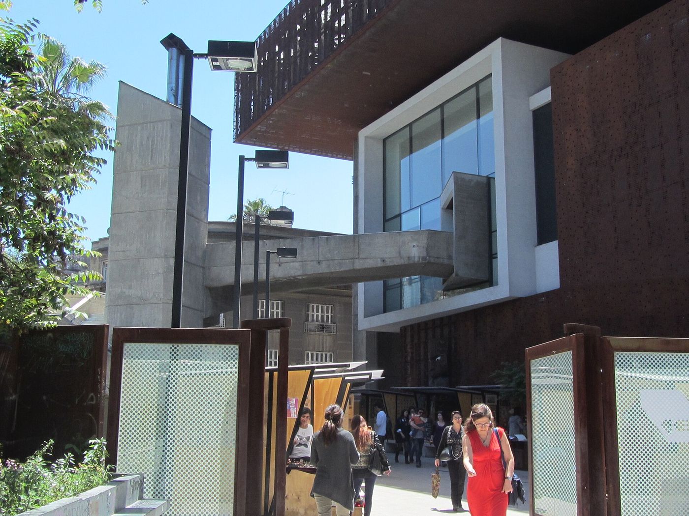 Glass and weathered steel western entrance of the GAM cultural centre on the Alameda in Santiago, with people outside