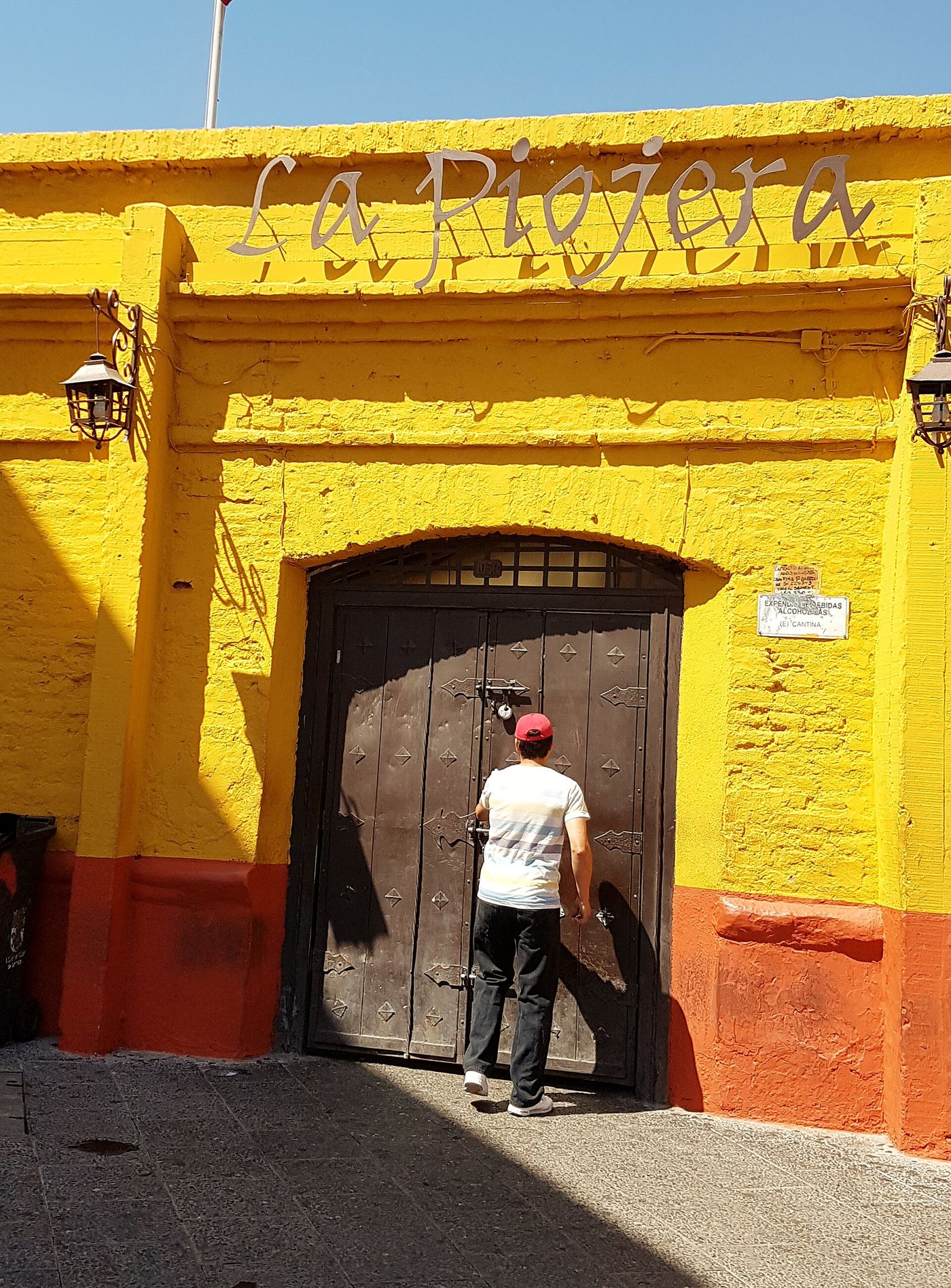 Bright yellow painted frontage and wooden doors of La Piojera, the historic terremoto bar near Mercado Central in Santiago