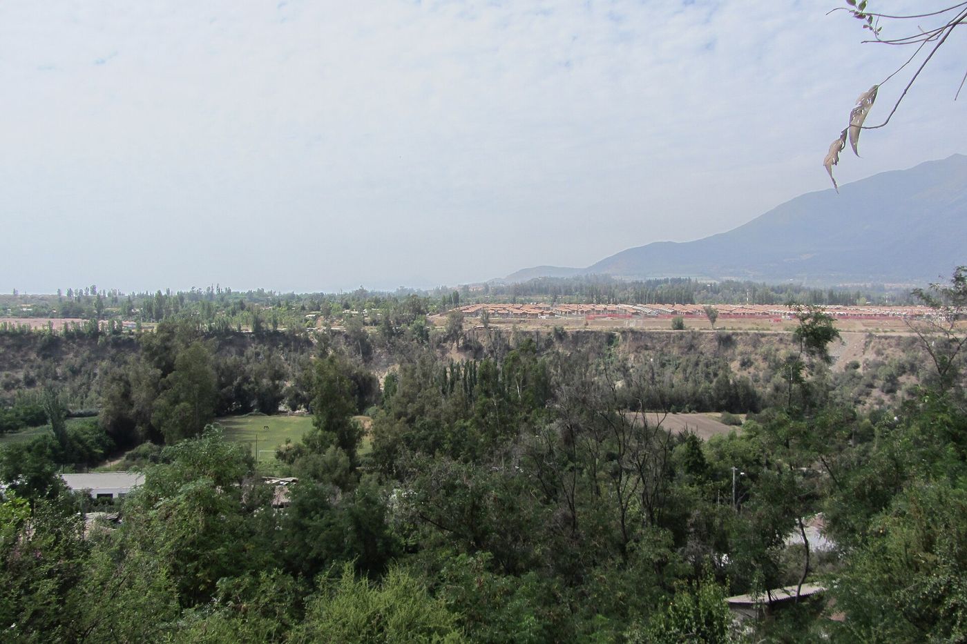 View across the green Maipo Valley toward the Andes foothills from Pirque, south of Santiago