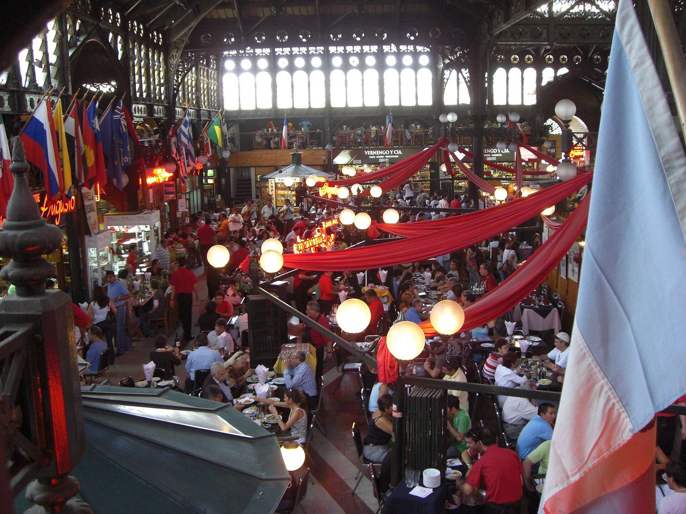 Crowded seafood restaurant tables beneath the iron roof of Mercado Central in Santiago