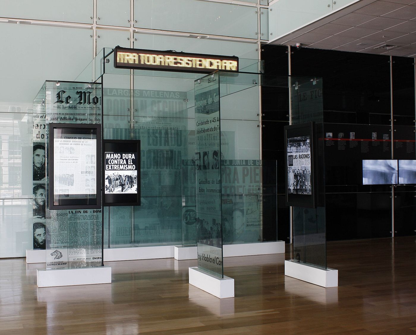 Exhibition gallery inside the Museo de la Memoria y los Derechos Humanos in Santiago, with glass display panels and archive screens