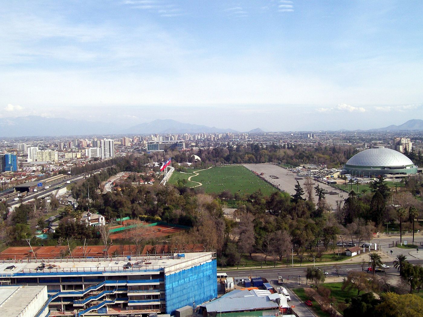 Aerial view over Parque O'Higgins in Santiago, with sports grounds, trees and the city beyond