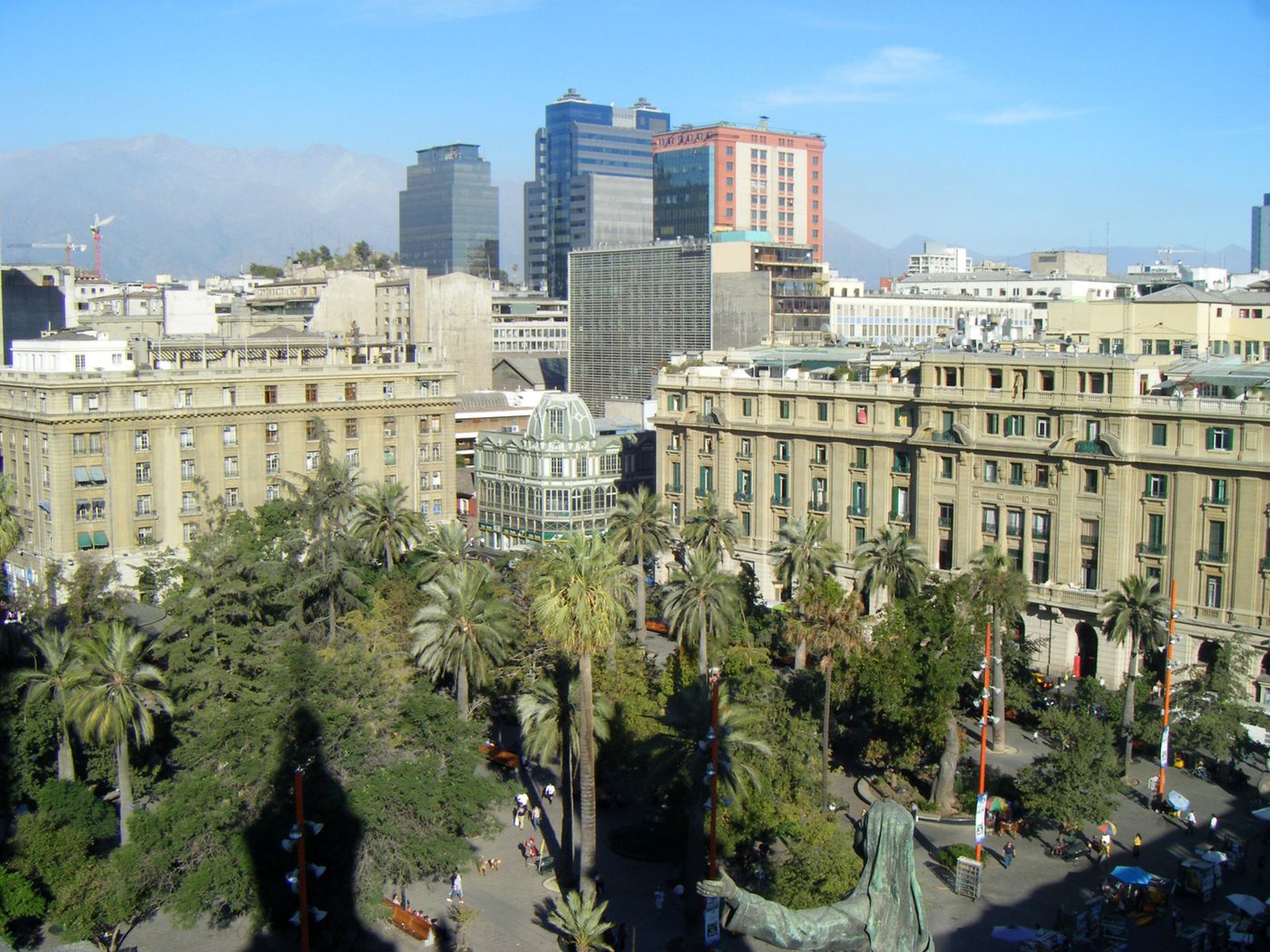 Aerial view of Plaza de Armas in Santiago with palm trees, historic buildings and the Andes in the distance