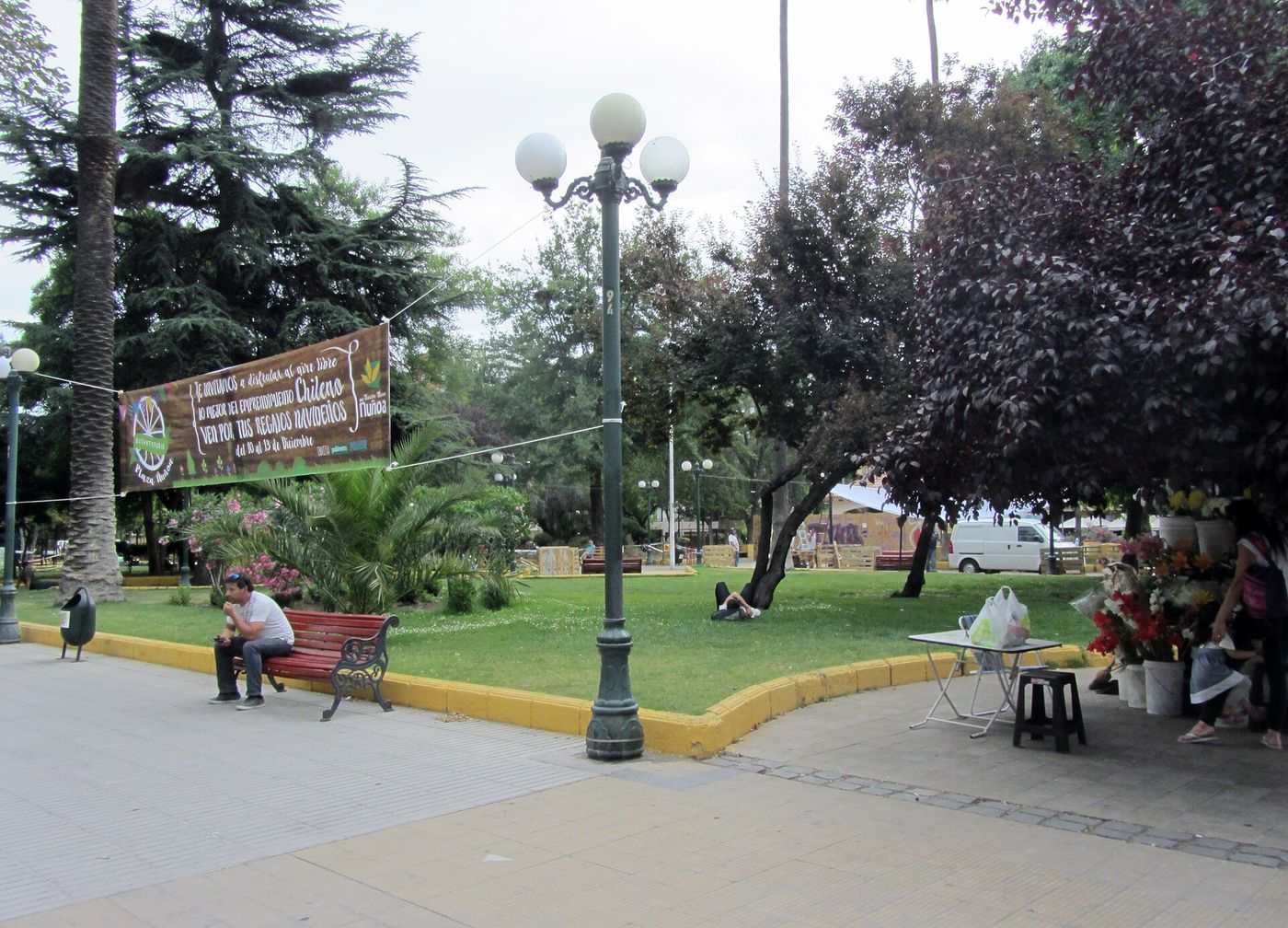Trees, benches and people sitting in Plaza Nunoa, the square at the centre of Nunoa's bar and theatre district in Santiago