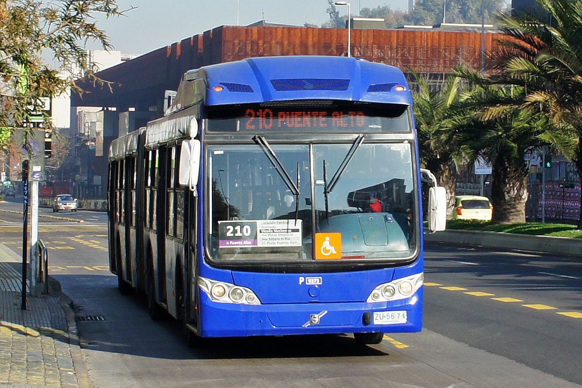 Blue articulated RED bus pulling away from a stop on a Santiago street