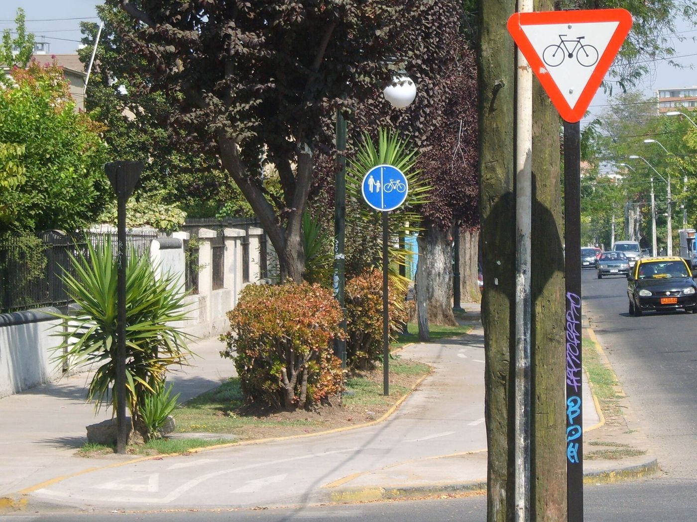 Bike lane signage and a separated cycle path beside a residential street in Nunoa, Santiago