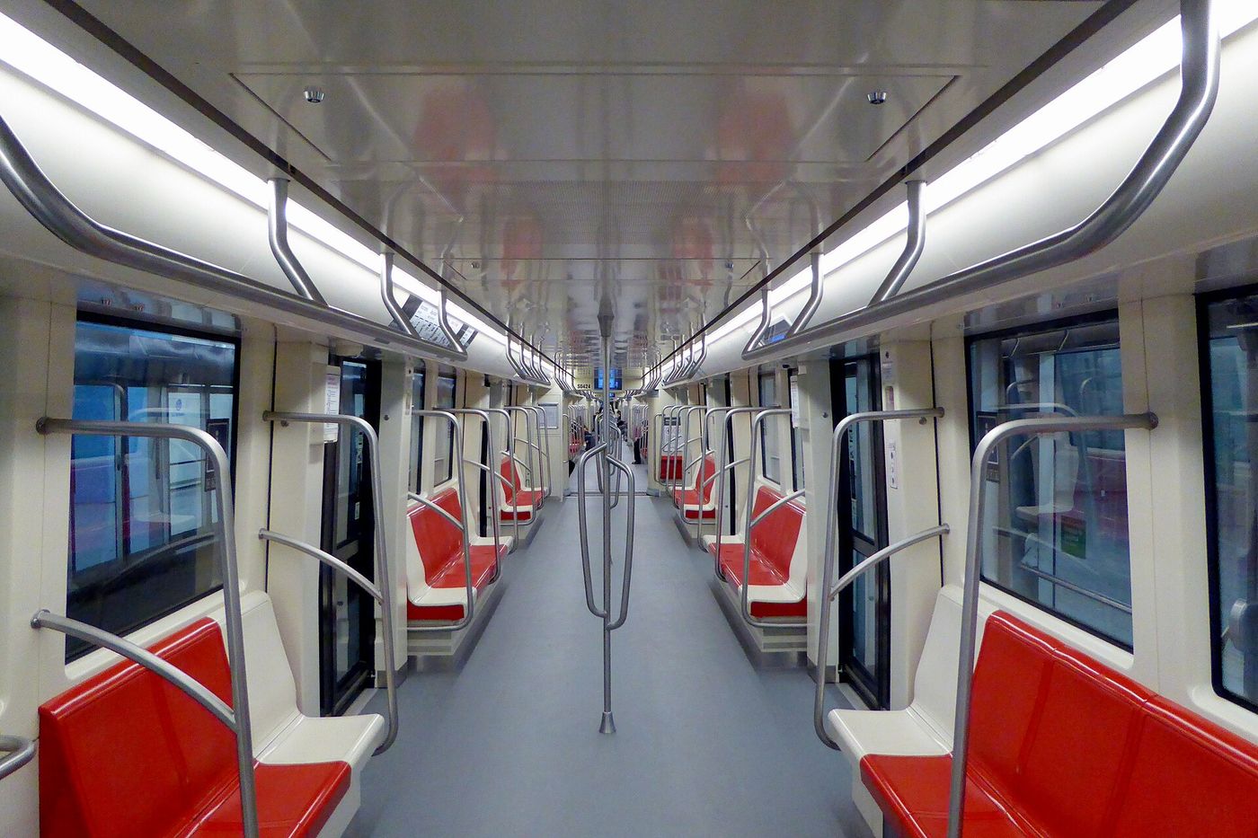 Interior of a modern Santiago Metro train with red seats and an open gangway