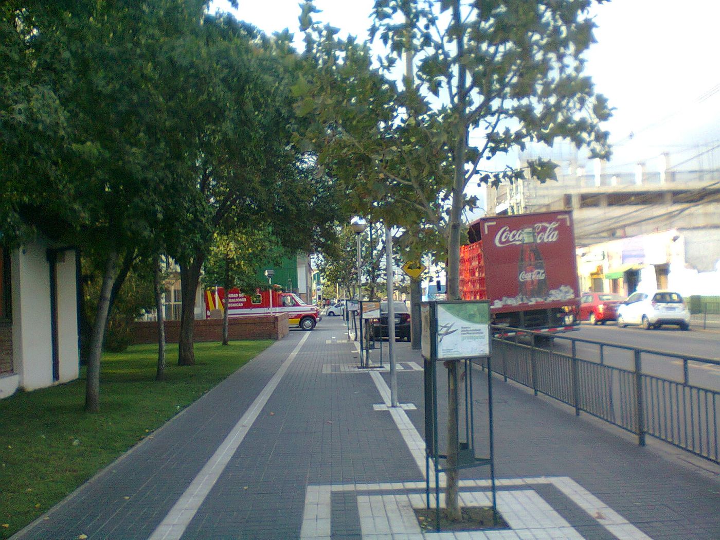 Paved sidewalk and bus shelter along a wide street in Santiago, Chile, with a cycle lane alongside