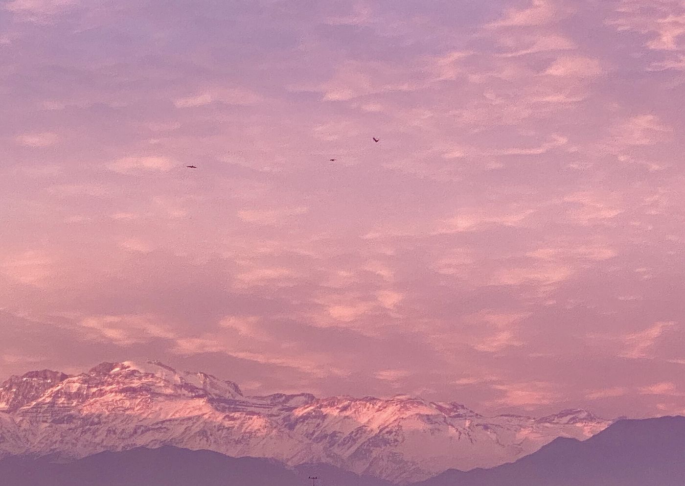 Pink sunset over the Andes seen through the winter haze above Santiago