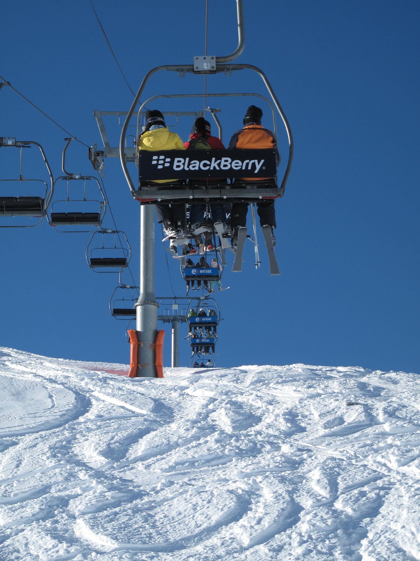 Skiers riding a chairlift above groomed pistes at Valle Nevado in the Andes above Santiago