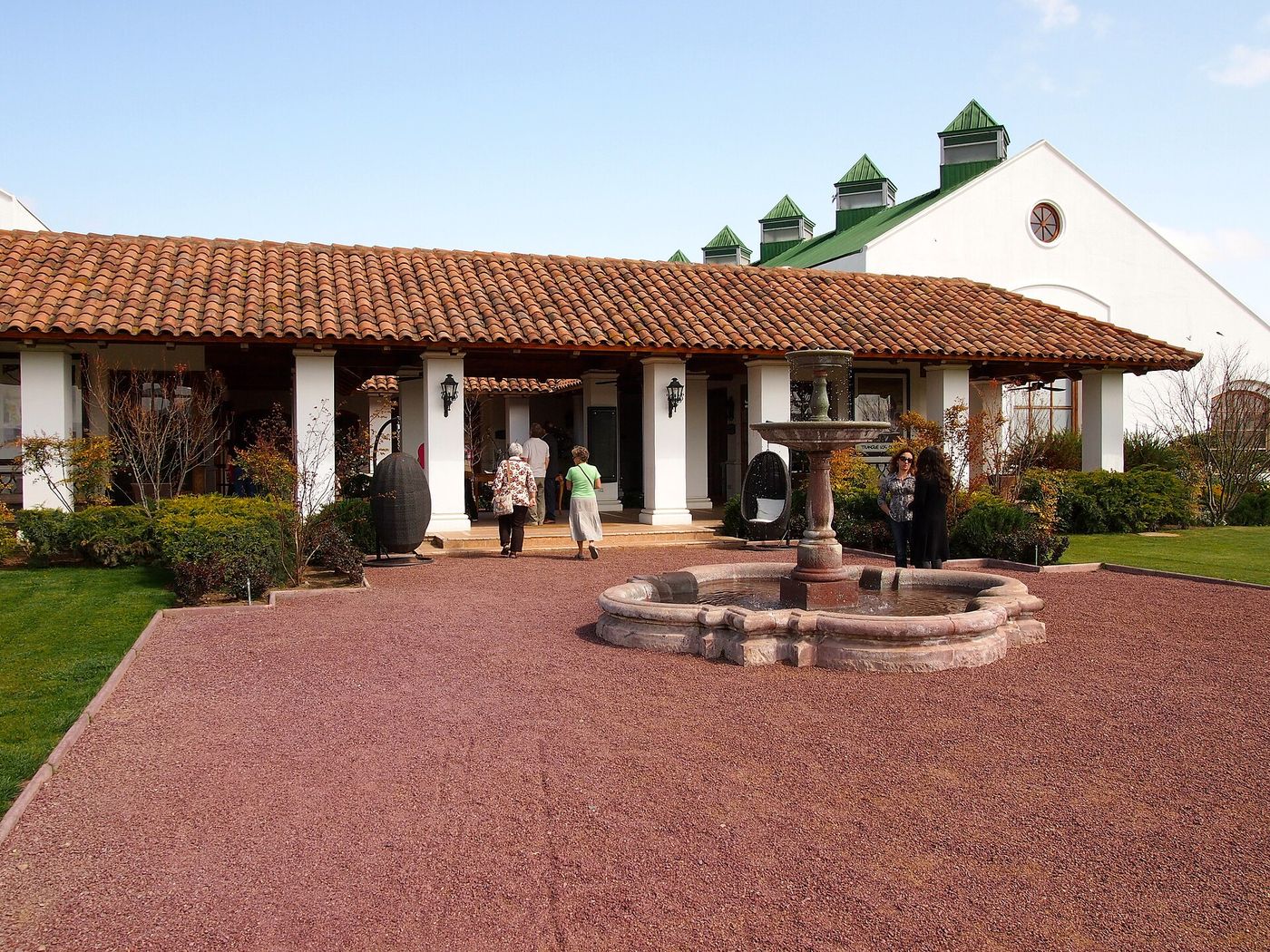 Visitors in the gravel courtyard of Viña Casas del Bosque in the Casablanca Valley, with a fountain and tiled veranda