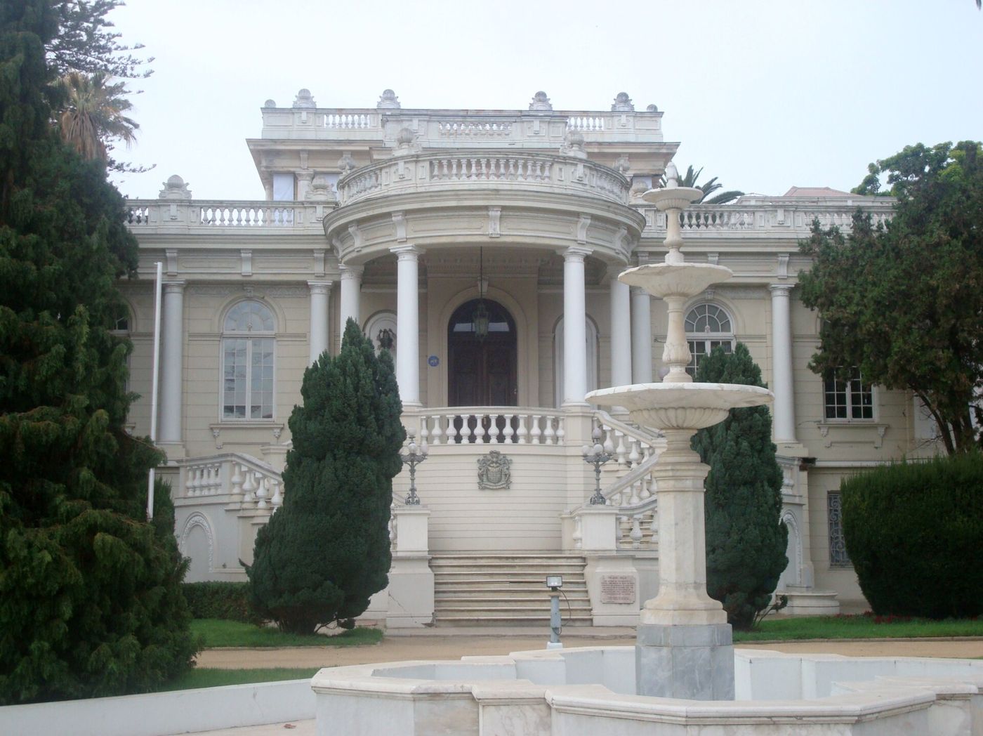 The white Belle Époque Palacio Rioja with columns and a domed portico behind a marble fountain
