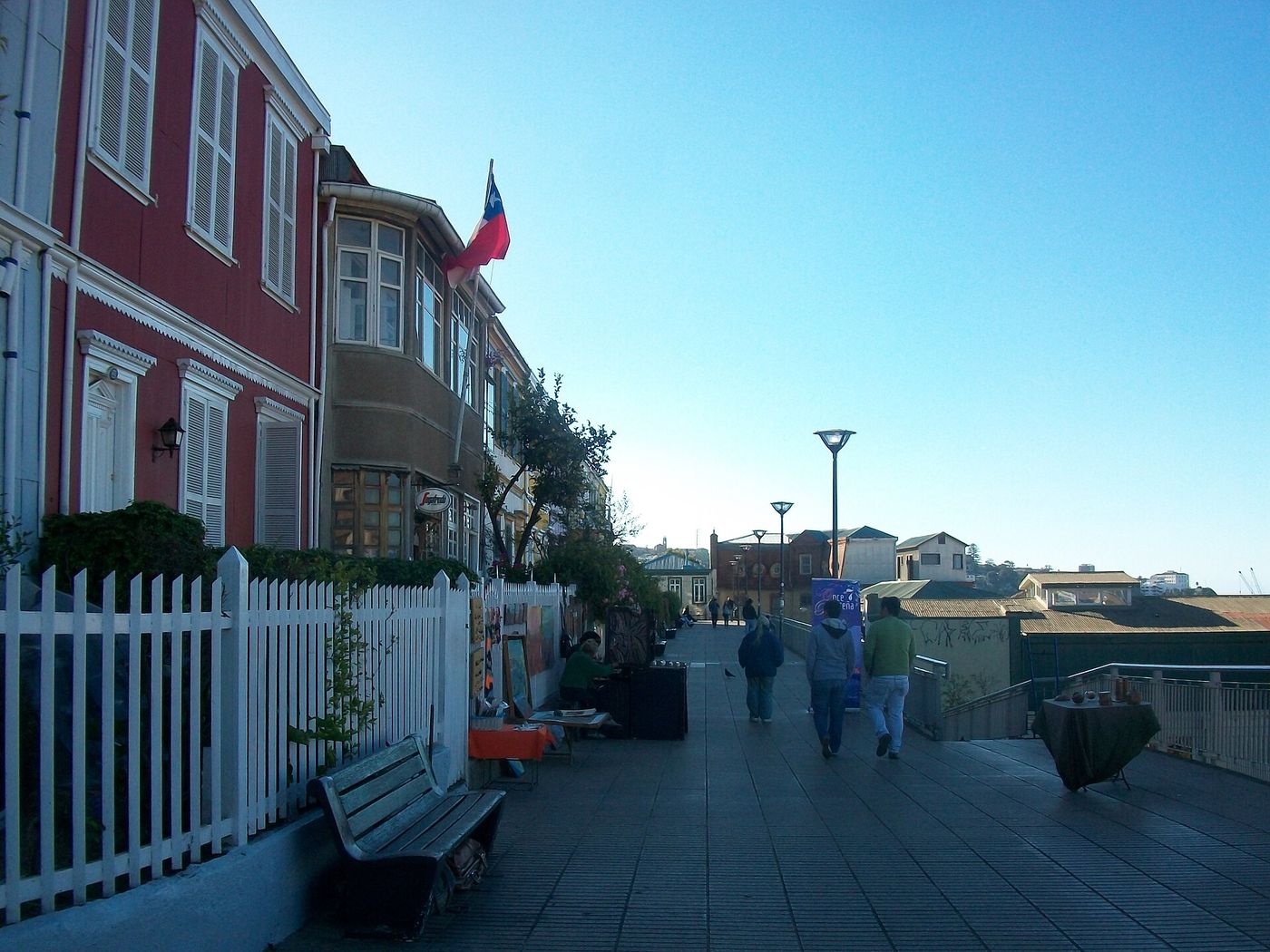 Painted wooden houses and a white picket fence along the Paseo Atkinson terrace on Cerro Concepción