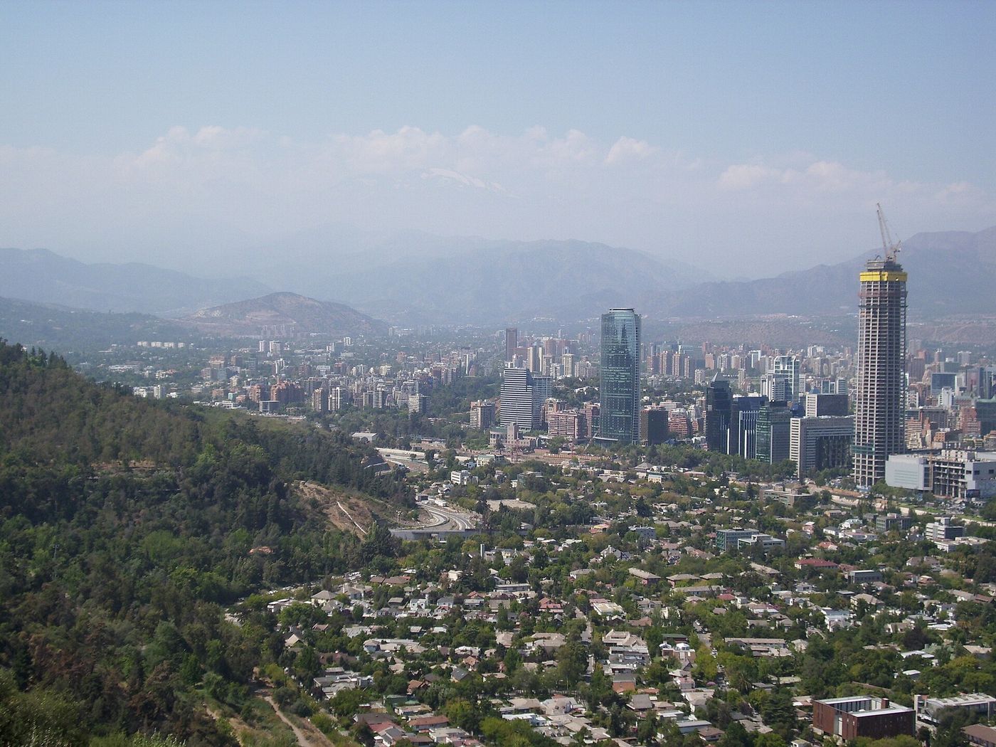 View from Cerro San Cristóbal over the low houses and trees of Pedro de Valdivia Norte toward Providencia's towers