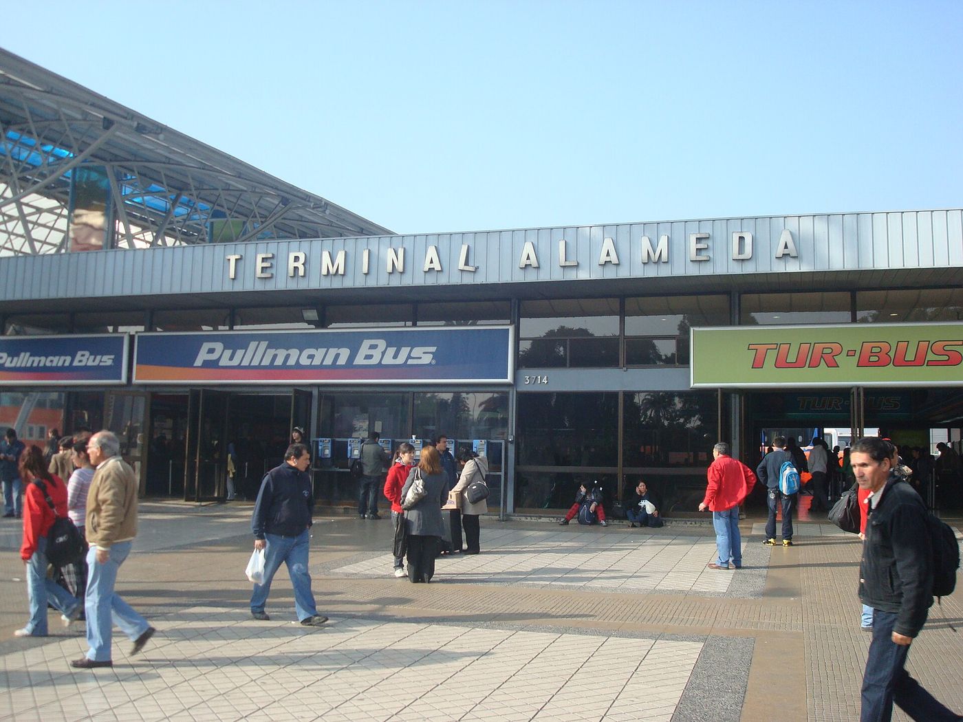 The entrance to Terminal Alameda in Santiago with Pullman Bus and Tur-Bus signs and travelers walking past