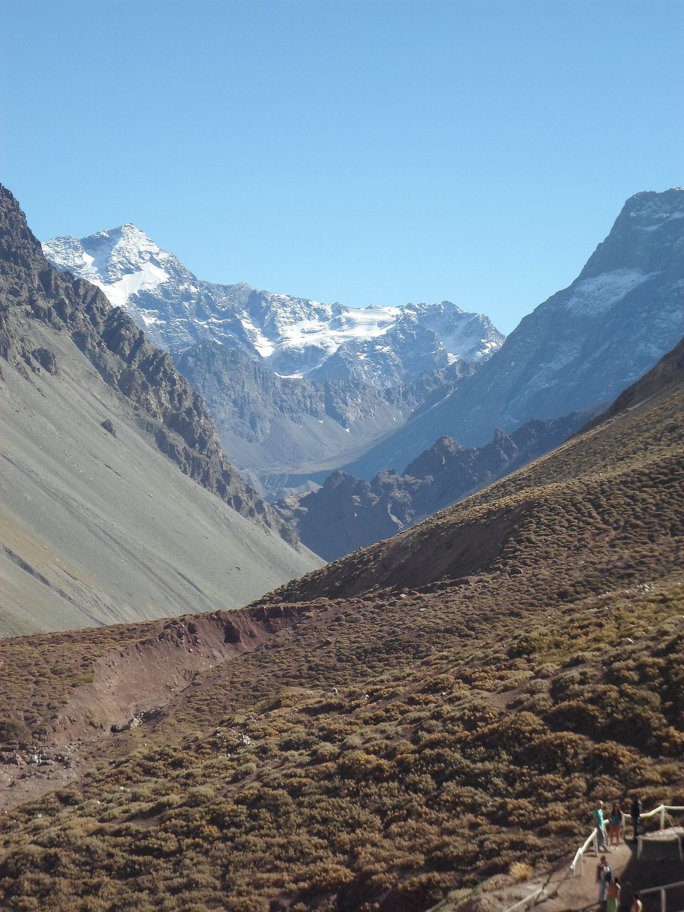 A steep bare valley rising to a snow-covered peak near the Valle de Colina hot springs